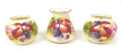 Three pieces of Royal Worcester by Kitty Blake, comprising a pair of globular vases, 7cm high,