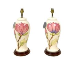 A pair of late 20th century Moorcroft magnolia pattern electric lamp bases, both 37cm high