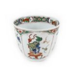 A Chinese porcelain tea bowl, Kangxi mark and period, decorated in famille verte palette with four