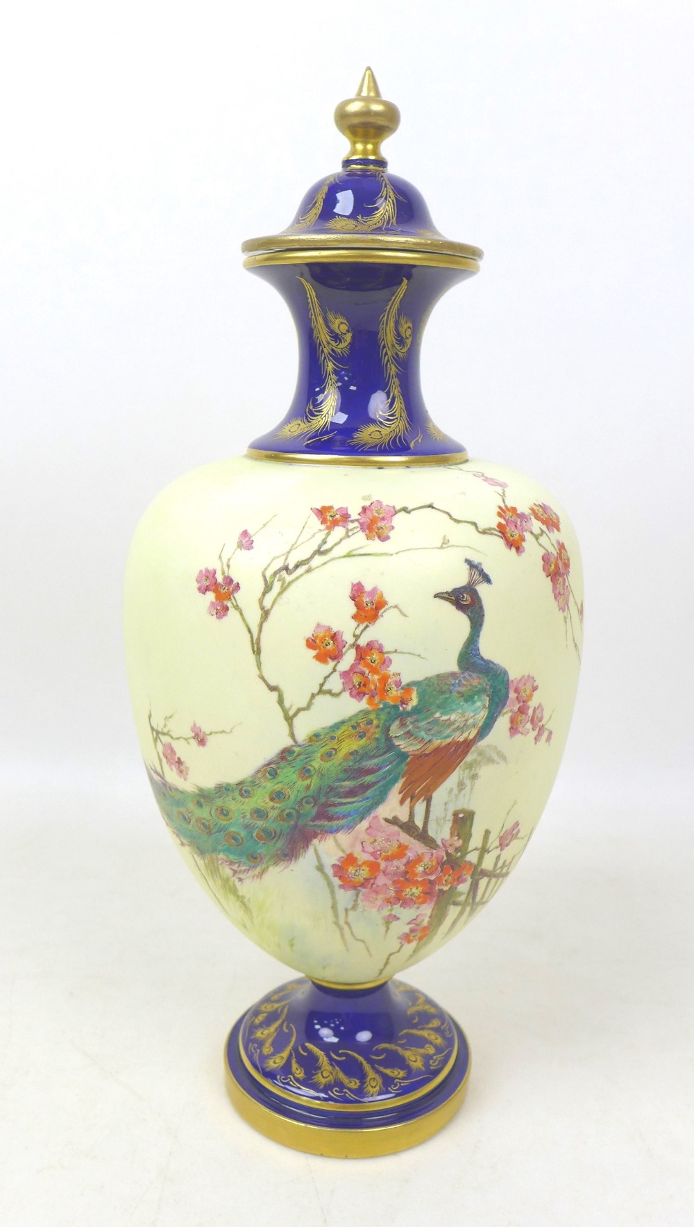 A Royal Worcester vase and cover, painted with a peacock perched on a branch in a blossom tree, on