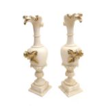 A pair of 19th century alabaster urns, the spouts carved as a birds beaks, with moulded flower and