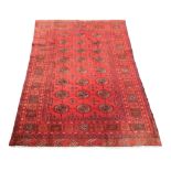 A Turkman rug, red ground with twenty-four medallions to its centre, geometric patterns to its