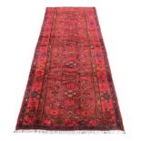 A Karajeh runner, with red ground, foliate and geometric patterns, 304 by 114cm.
