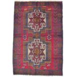 A new Baluchi rug, with red ground, two central medallions and a stylised foliate motif border,