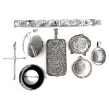 A collection of silver brooches and pendants, including locket pendants, a cross pendant, and an