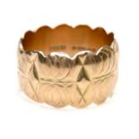 A 9ct gold wide ring with scalloped edges and engraved design, size Q/R, 12mm wide, 7.4g.