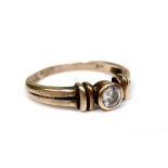 A 9ct gold and white stone solitaire ring, of modern design with double banded shoulders and central