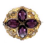 A Victorian gilt brass brooch set with amethysts, the four oval stones each 18 by 12 by 6mm, and