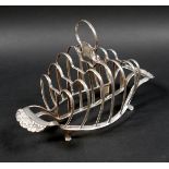 A George III silver six division toast rack, with heart shaped dividers and shell handles, raised on