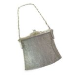 An early 20th century silver ladies chainmail bag, floral engraved frame with chainmail link bag and