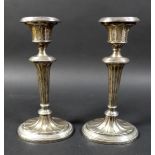 A pair of silver candlesticks, on green leather bases, George Unite & Sons, Birmingham 1902, total
