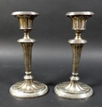 A pair of silver candlesticks, on green leather bases, George Unite & Sons, Birmingham 1902, total