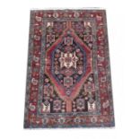 A Hamadan rug, with red ground, central caucasian medallion and two narrow blue borders, 198 by