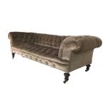 An early 20th century Chesterfield settee, with button back pale brown upholstery, raised upon