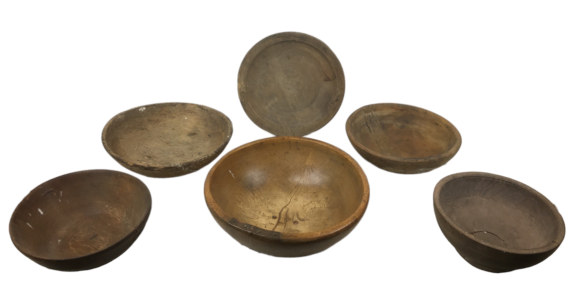 Five rustic wooden bowls, largest of walnut with metal mounted repairs, 43 by 15cm high, together