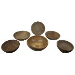 Five rustic wooden bowls, largest of walnut with metal mounted repairs, 43 by 15cm high, together