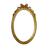 A reproduction 19th century style gilt framed oval mirror, decorated with ribbon surmount, 54 by