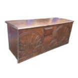An 18th century coffer, with two carved lunettes to its front, lock filled in and covered with an