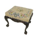 An 18th century footstool, with later upholstery and cabriole legs with ball and claw feet, 61 by 50