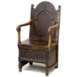 A 17th century oak Wainscot chair, the open arms with scroll carved ends, lift lid to box seat