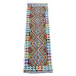 A Chobi Kilim runner, decorated with a row of five lozenges to central panel, surrounded by a