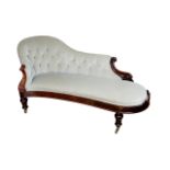 An Edwardian chaise longue, with walnut frame, button back grey upholstery, raised upon turned