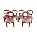 Six Victorian mahogany balloon back dining chairs, with upholstered seats, raised upon turned