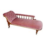 An Edwardian chaise longue, with mahogany frame and pink upholstery, button back, raised upon turned