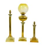 Three brass lamps with Corinthian column style bases, comprising an Edwardian oil lamp with yellow