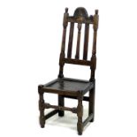 An 18th century oak hall chair, the high back with three splats, below a carved top rail, a solid