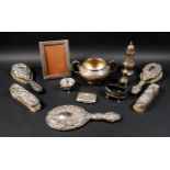 A group of mixed silver items, including a twin handled bowl, sugar caster, pepper, three legged