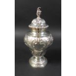 A Victorian silver urn, with conch shell finial and profuse floral repousse decoration and two blank