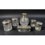 A collection of silver lidded cut glass dressing table jars, including a four piece set by