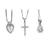 A group of three 9ct white gold and diamond pendants, comprising a teardrop, a leaf, and a cross,