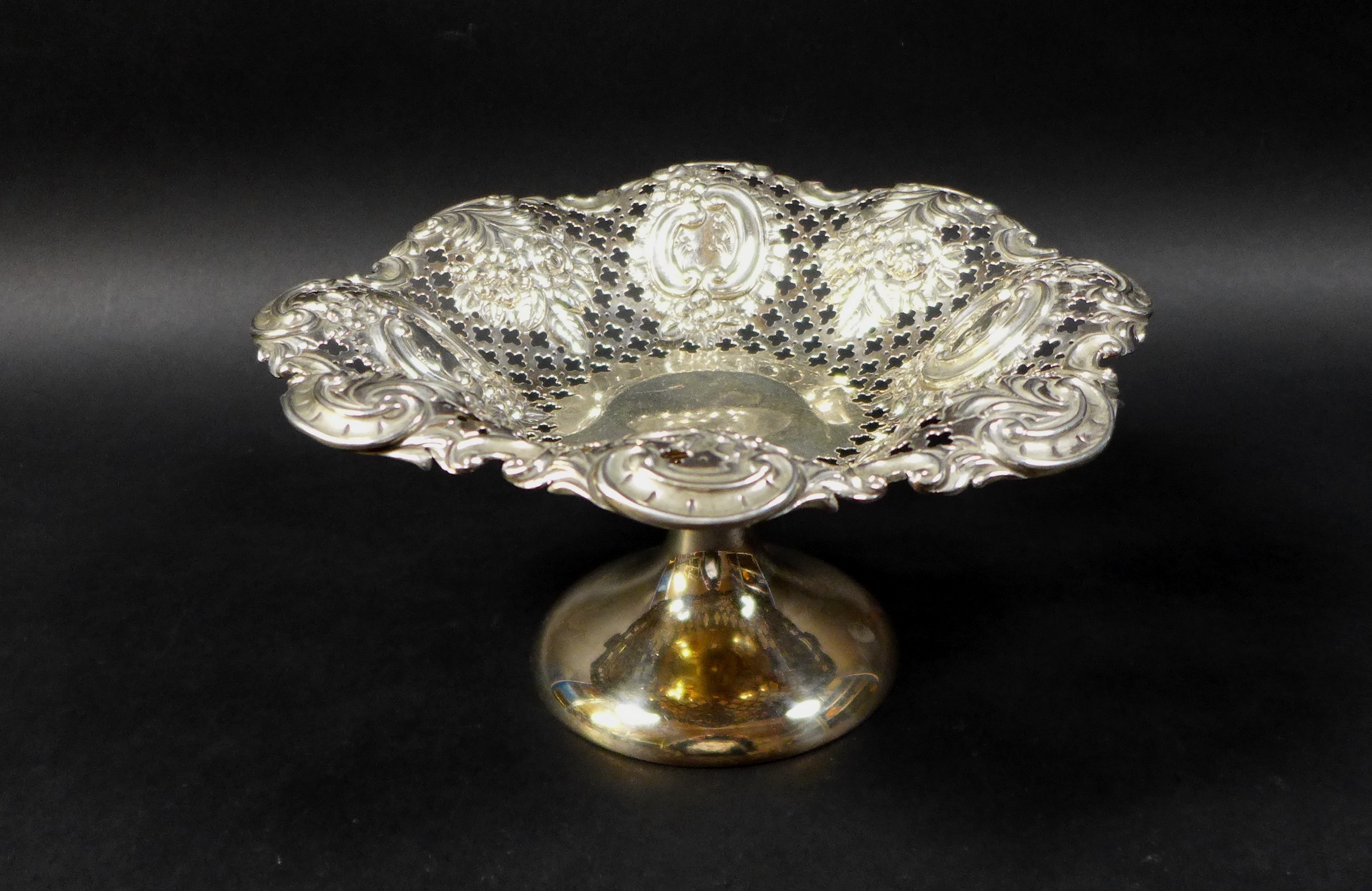 A silver bon bon dish, with foliate and scroll designs and pierced decoration to its bowl, raised