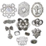 A group of eleven silver and white metal brooches, and a part belt buckle, 19th century and later,