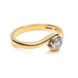 An 18ct yellow gold solitaire diamond crossover ring, the round brilliant cut stone, 4.0 by 2.5mm,