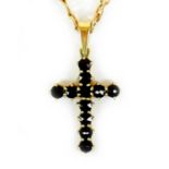 A 14ct gold and garnet cross pendant, set with eleven round cut stones each of 3.1mm, cross