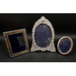 Three ERII silver photograph frames, comprising an oval form frame, decorated with foliate and