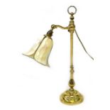 A modern brass effect table lamp, with Tiffany style flower head yellow / cream shade, column