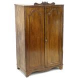 A 19th century mahogany cupboard, with shaped cornice, twin doors enclosing two shelves, above a