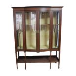 An Edwardian mahogany display cabinet, twin door, bow fronted, with two lined shelves, raised on