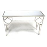 A modern dressing table, with silvered and mirrored finish, two drawers, raised on tapering legs,