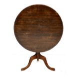 A George III oak tilt top occasional table, with circular top, turned column and tripod base, 91