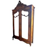 A 20th century walnut armoire, with scroll surmount, two mirrored double doors, 139 by 47 by