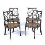 A SET OF FOUR FRENCH EMPIRE STYLE EBONISED AND WHITE PAINTED OPEN ARMCHAIRS (4)