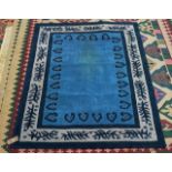 A MACHINE MADE RUG, PLAIN BLUE FIELD WITH SINGLE STYLISED MOTIFS, AN IVORY BRANCH BORDER
