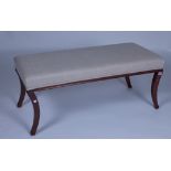 A RECTANGULAR WINDOW SEAT ON SABRE MAHOGANY SUPPORTS