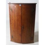 A 19TH CENTURY OAK BOWFRONTED HANGING CORNER CUPBOARD