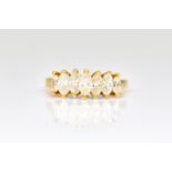 A GOLD AND DIAMOND SET SEVEN STONE RING